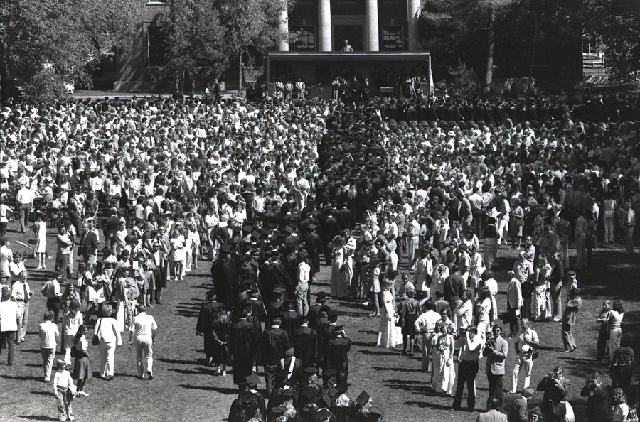The graduates proceed through the Quad at commencement.