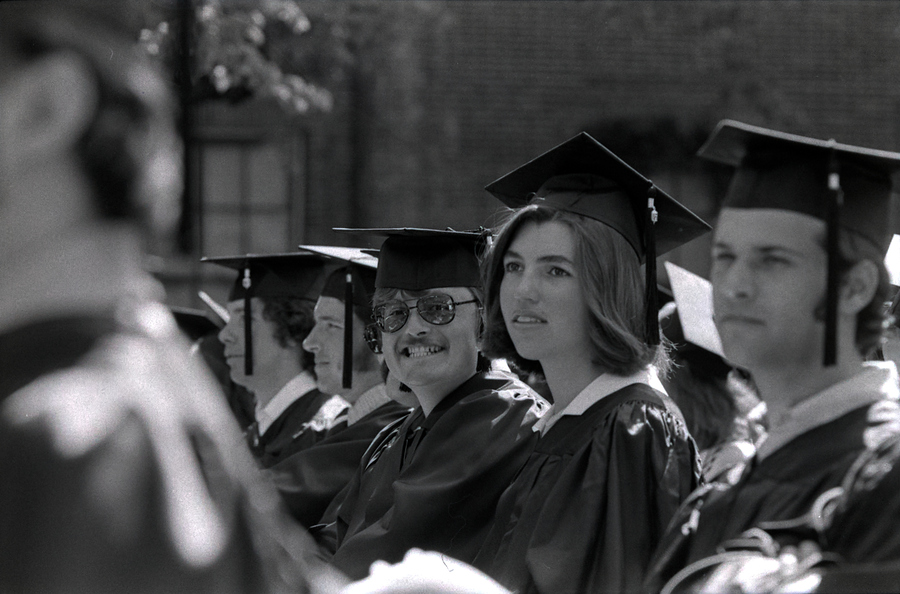 Students sit in chairs at commencement while waiting to be called.