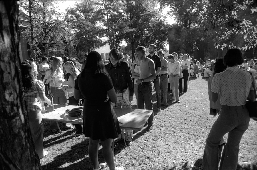 Students line up at tables on the quad.