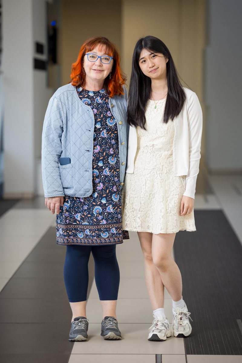 Mentor Elena Pravosudova with Scholar Megan Nicole Huynh posing in a hallway.