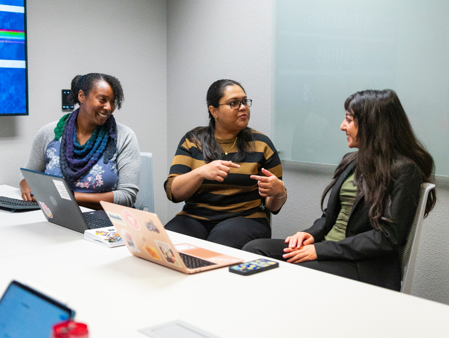 Students working with Sarah Mitchell at a table.
