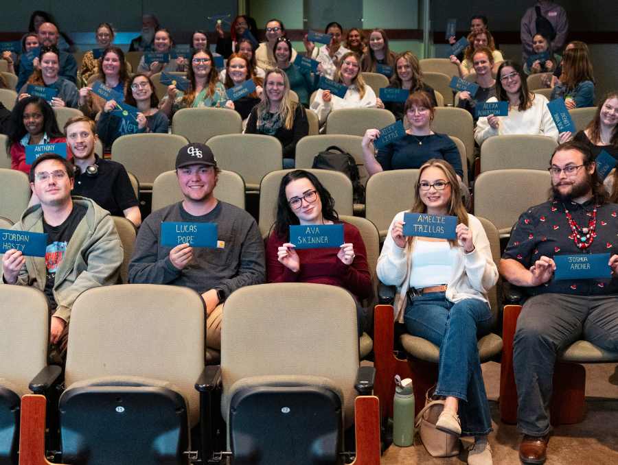 Students showing envelopes that contain their placement for the fall.