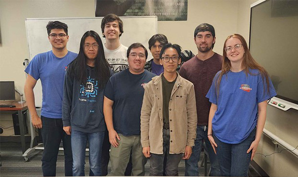 Eight people stand in a classroom.