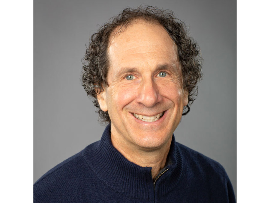 A portrait of David Leitner against a gray background.
