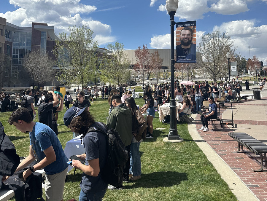 Students gather on the lawn at the University of Nevada, Reno, visiting booths and browsing products during the ENT 200 Sales Expo, a student-run marketplace showcasing microbusinesses.