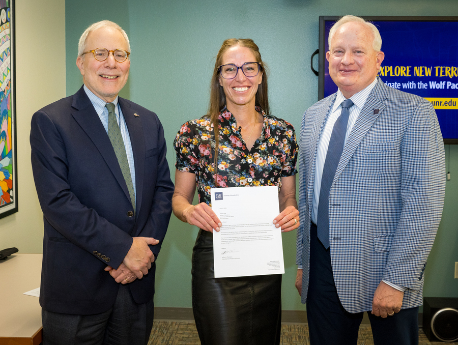 Professor Megan Biagi is presented Tibbits award from School of Medicine dean Paul Hauptman and Provost Jeffrey Thompson. 