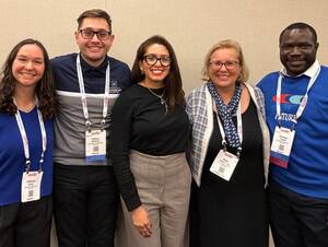 Dean of the School of Public Health with graduate students and alumni at the APHA 2025 conference.