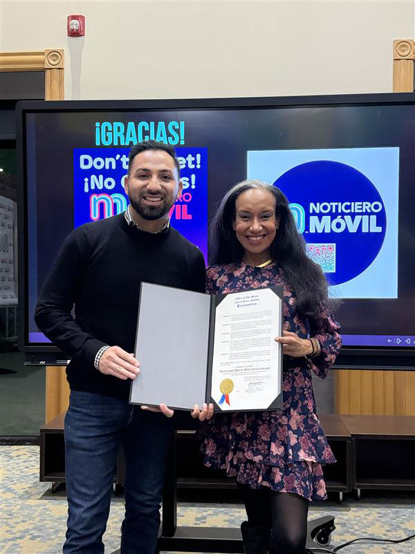 Diego Zarazúa presenting Claudia Cruz with a certificate of recognition from the city of Reno. 