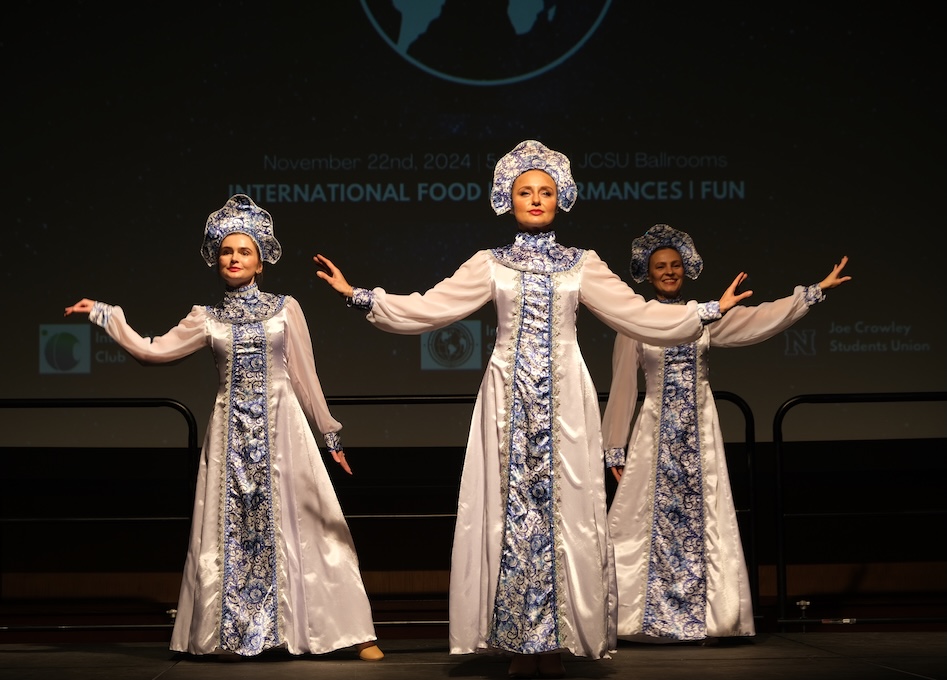Three women dancing on stage in special costumes.