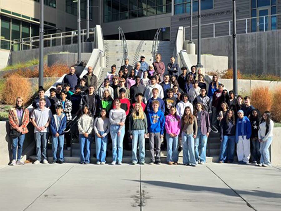 Group around 50 young people standing in rows about 15 people deep on an outdoor stairway.