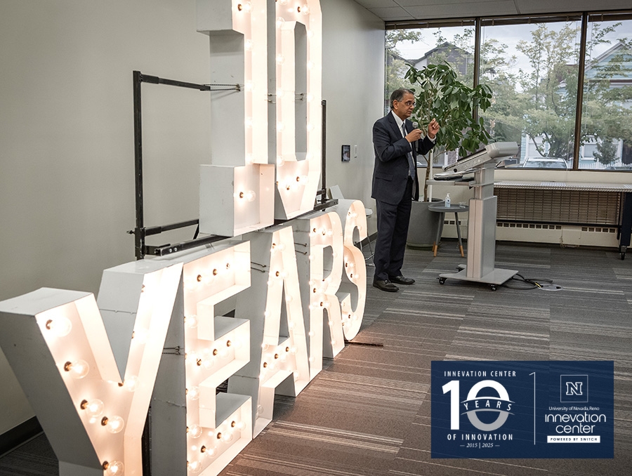 A person is giving a speech at a podium beside large illuminated letters spelling "10 YEARS" at an anniversary event in the Innevation Center.