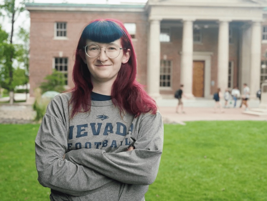 Alexia standing, smiling on the University's quad, while wearing a Nevada t-shirt.