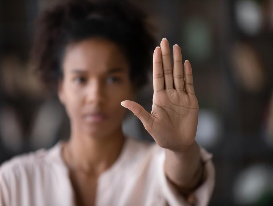 A woman holding her hand out in a stop gesture.