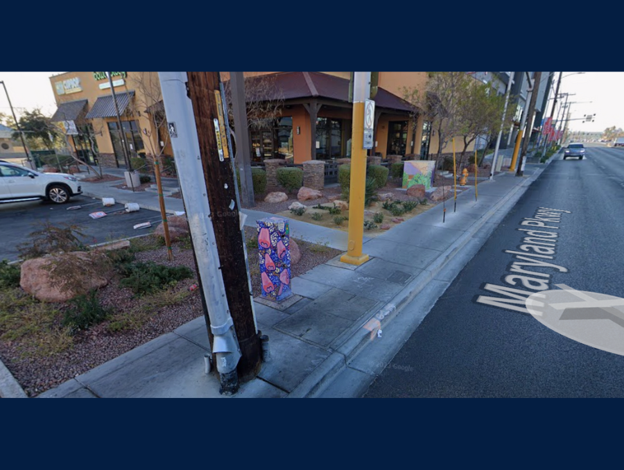 An aerial view of a street lined with poles with a store on the left hand side.