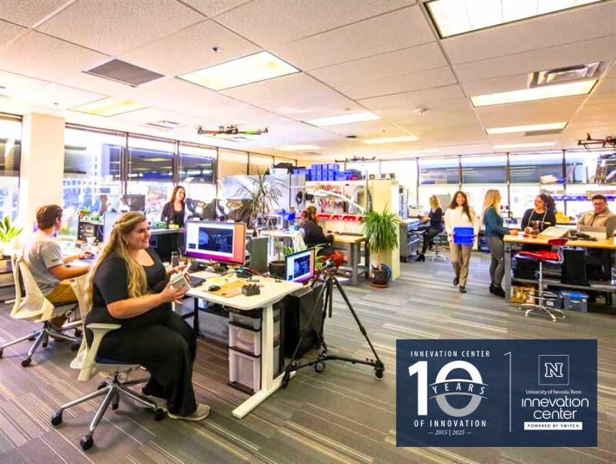 Open office space at the UNR Innevation Center with several individuals working at desks. There is a celebratory banner marking "10 Years of Innovation from 2015-2025."