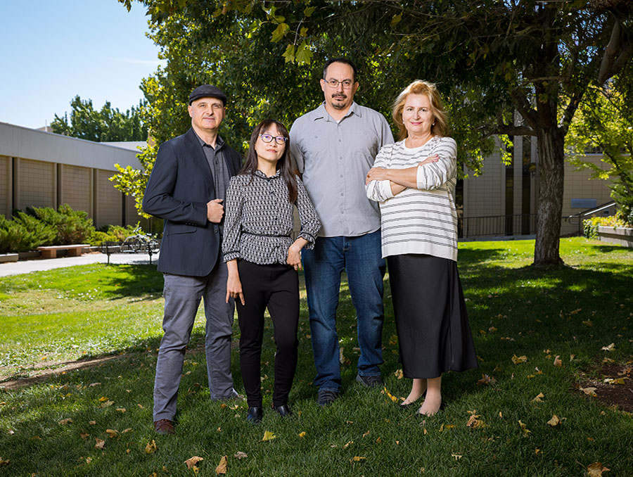 Four researchers posing outside the medical school research buildings on the University of Nevada, Reno campus.