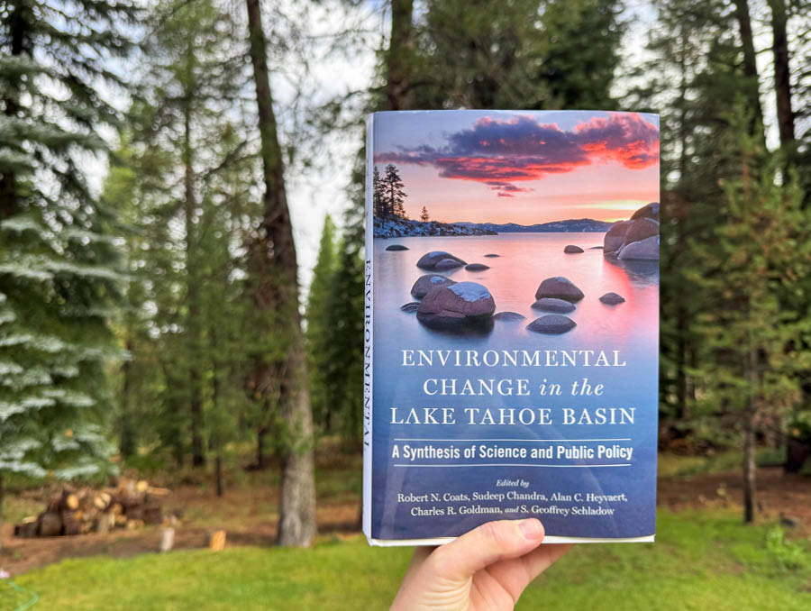 A person holds up the book Environmental Change in the Lake Tahoe Basin.