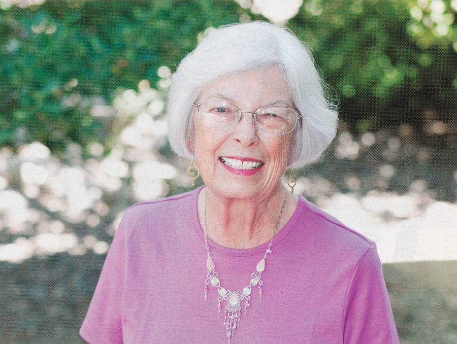 Portrait of Joan Zenan wearing a bright pink shirt.
