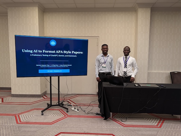 Two men stand next to a presentation screen entitled "Using AI to Format APA Style Papers."