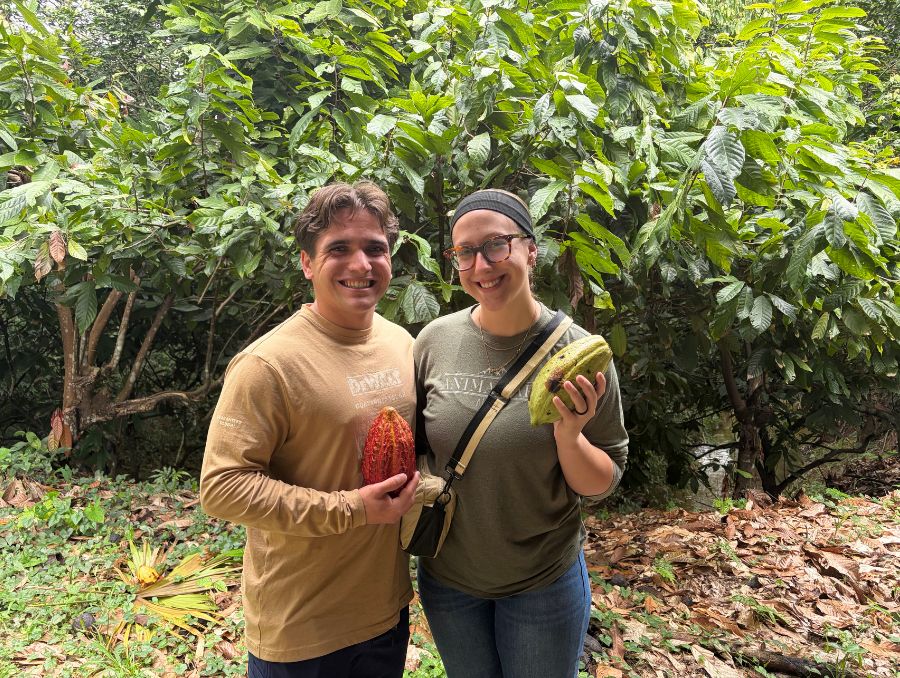 Lizzy Riley and Kye Nolan holding fruit in Belize