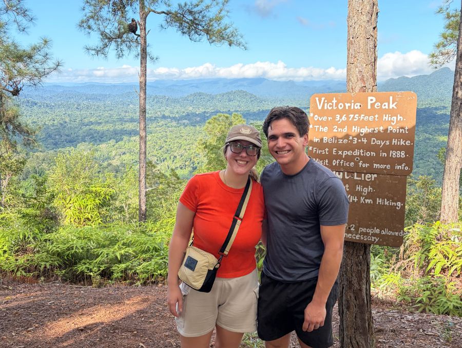 Lizzy Riley and Kye Nolan standing in front of a sign in Belize