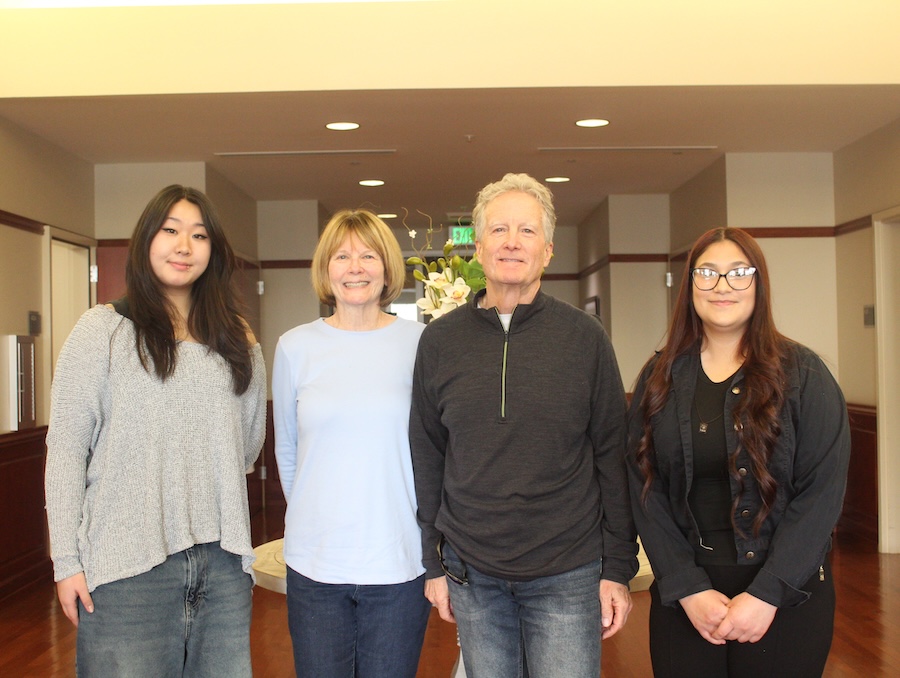 Two students on either side of John and Rochelle Gray.