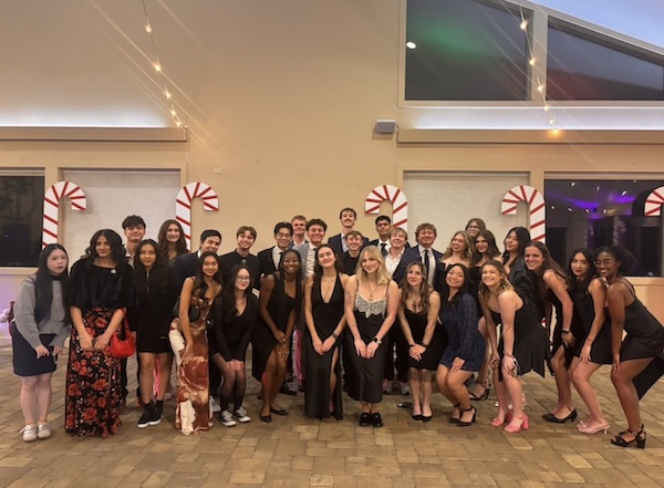 Laruen stands in the middle of a very large group of students dressed in semi-formal attire during an event.