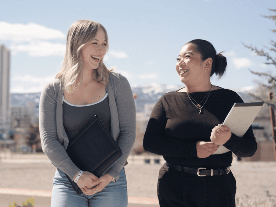 Laruen and her boss Pam walking near the business building while they look at one another.