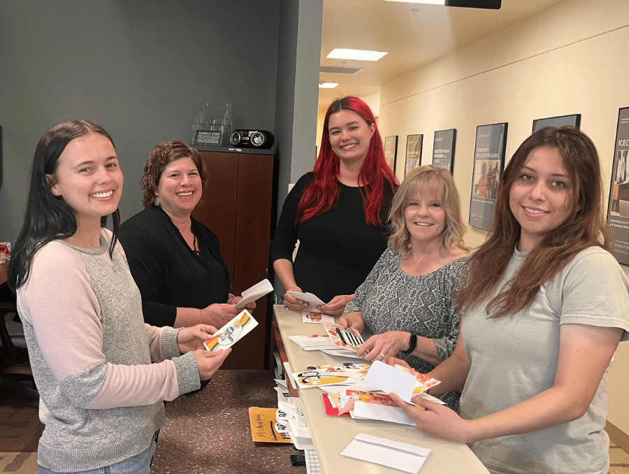 Sanford Center for Aging employees standing by a desk with greeting cards.