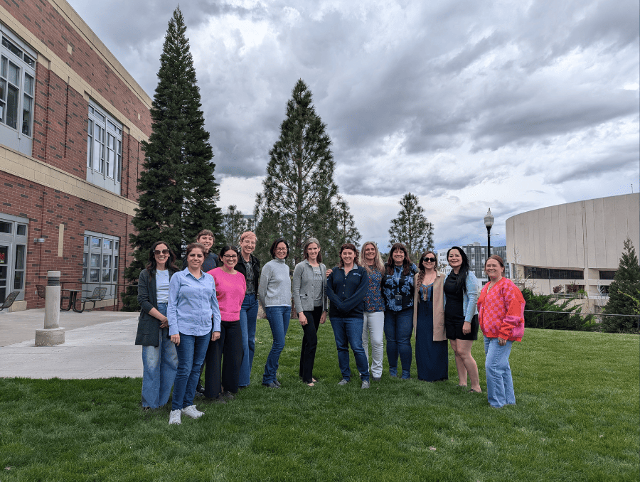 The committee on the status of women posing on campus.