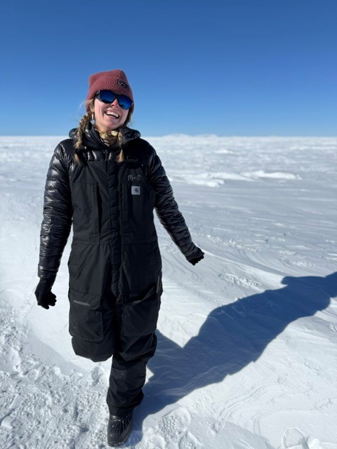 Dylen Swan on a mountain in the snow, jumping, wearing a snow suit.