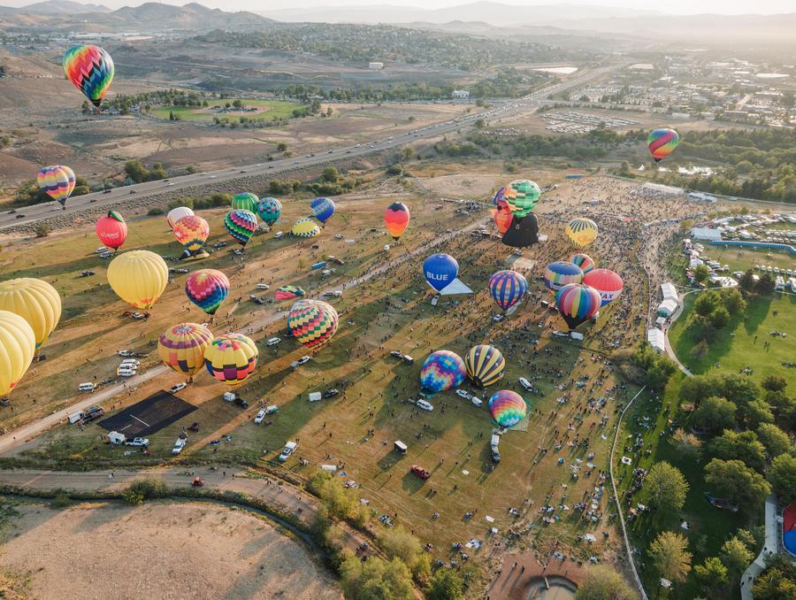 Hot air balloons floating around Reno, as seen from above.