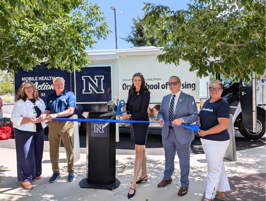 University officials doing a ribbon cutting in front of a Block N branded Orvis School of Nursing mobile health unit. From left to right: Jane Fox, Provost Jeff Thompson, Molly Kokenge, Dean Charlie Yingling and Natalie Davidson.