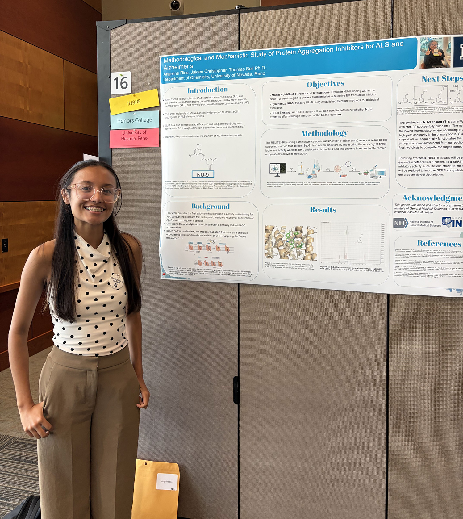 Angeline Rios stands by her research poster at Wolf Pack Discoveries.