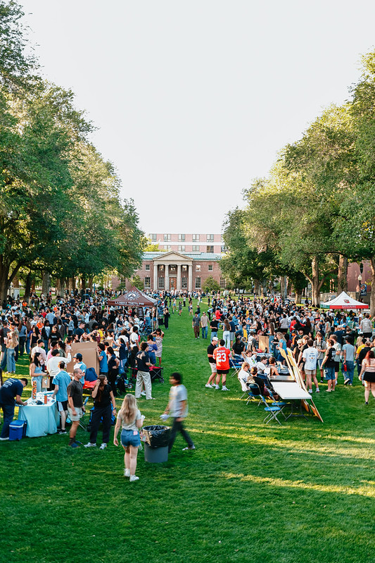 The quad, full of students, mingling around clubs and organizations who are tabling.