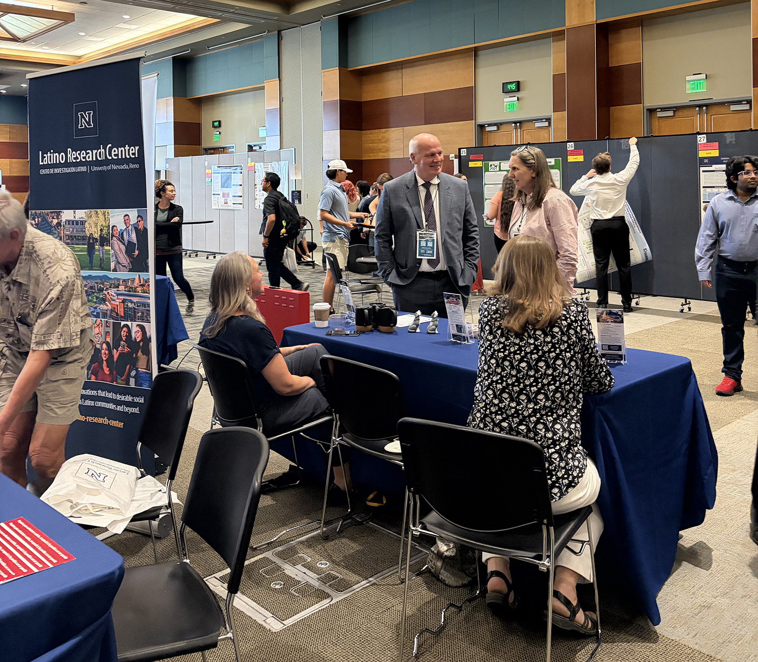 Data and Discovery resource fair with people at table and people standing.