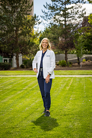 Jennifer Geddes in a white coat standing outside.