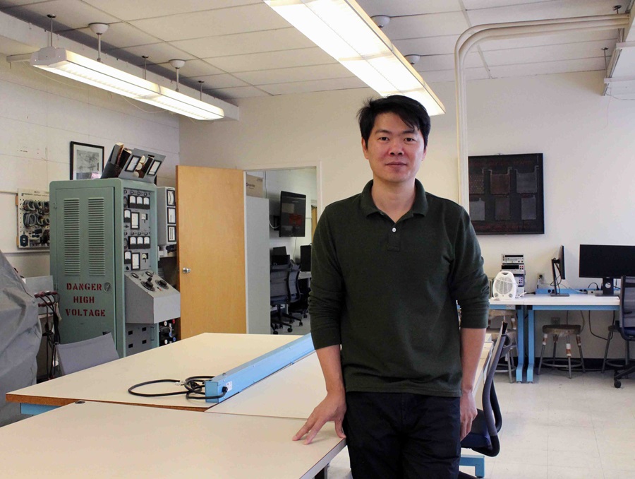 Xingang Fu standing in a lab.