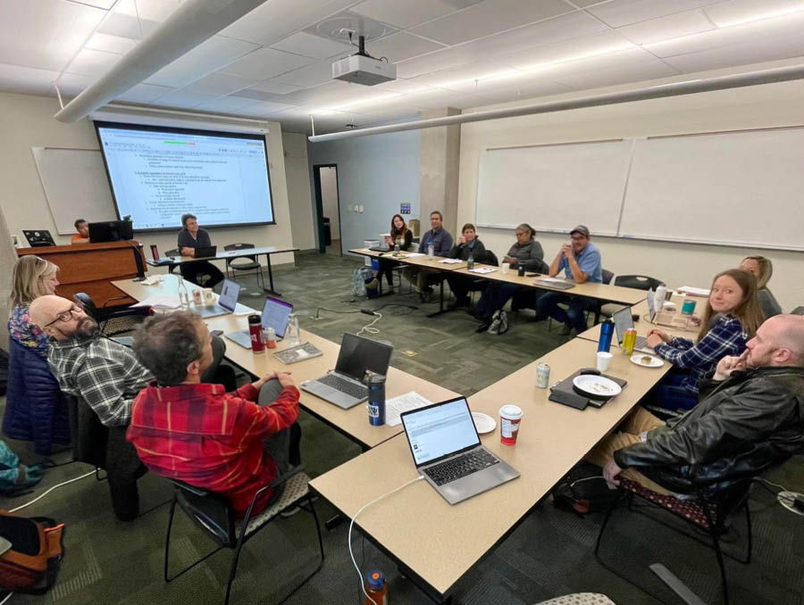 A group of researchers sit around a projector discussing Lahontan Cutthroat Trout.