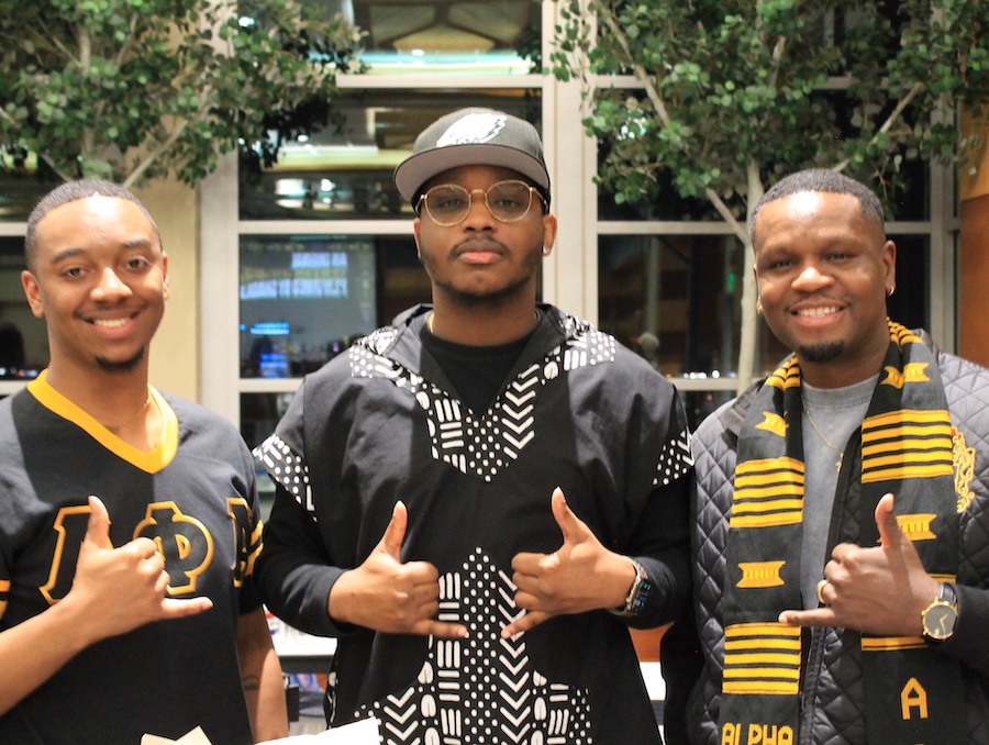 Three students smiling and holding a thumbs up.