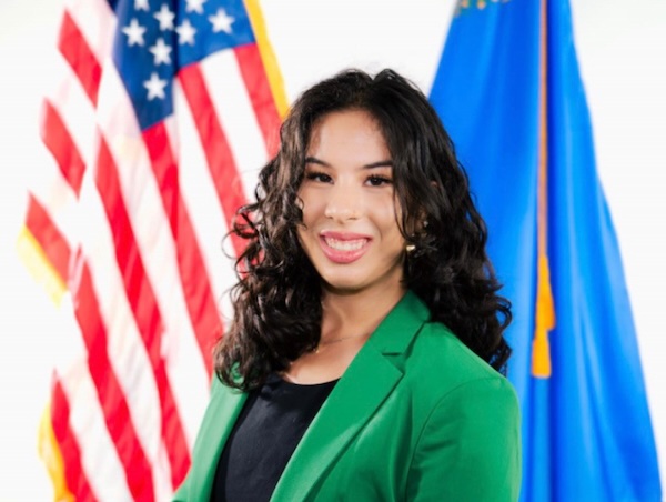Gabriella Detrick headshot in front of American and Nevada State flags.