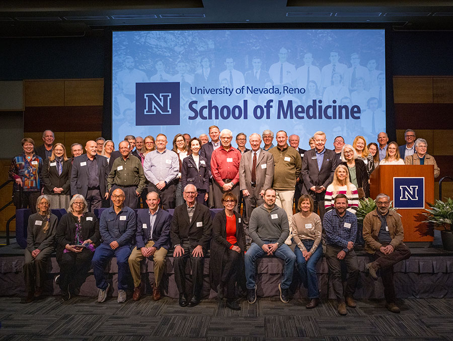 Kozel with medical school alumni from the last five decades on stage for a reunion photo at his retirement celebration.