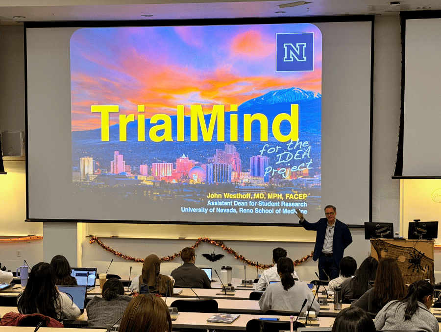 An instructor in front of a classroom in front of a slide that says "TrialMind" 