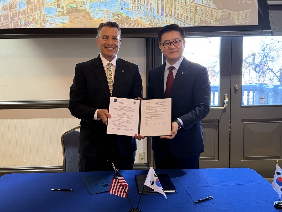 President Brian Sandoval and Ki-jeong Lee holding signed agreement.