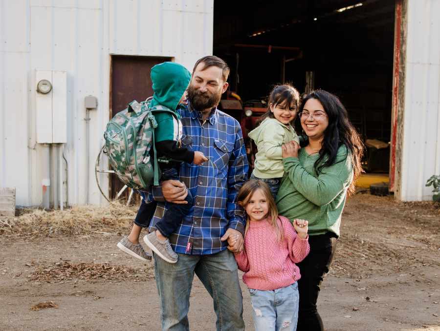 Family smiling at a farm.