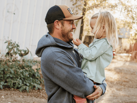 Dad and daughter smiling.