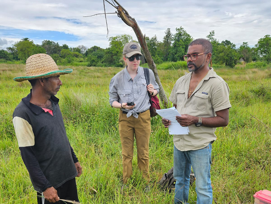 In the Sri Lankan grasslands, University of Nevada, Reno undergraduate student researcher Avery Nicholas (middle), interviews a Sri Lankan worker (left), with translation assistance from a staff member with the Sri Lanka Wildlife Conservation Society (right).