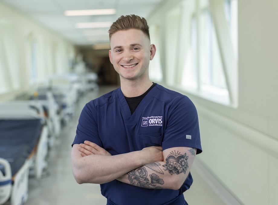 A nursing student in scrubs, smiling at the camera.