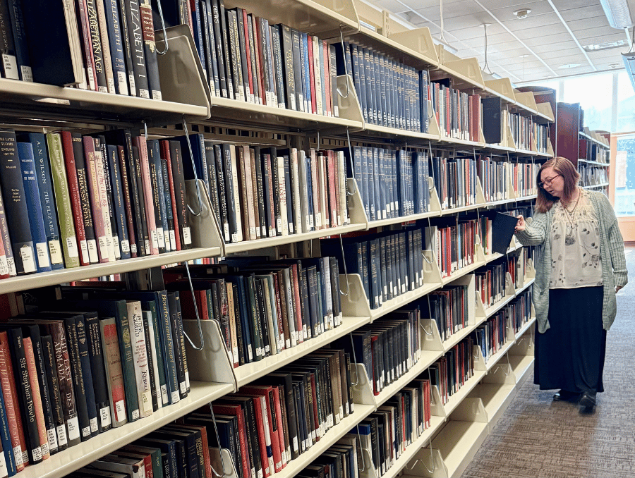 Orion Liggett in the University of Nevada, Reno library looking at a book.