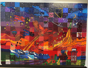 A mural of a sunset with birds, planes and other depictions of Nevada.
